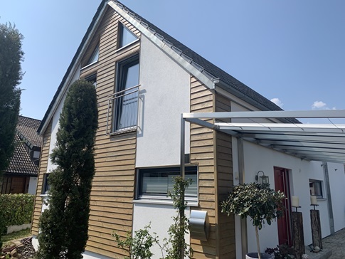 Putzfassade mit Fassadenelementen aus Holz