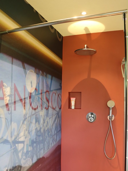 Badezimmer mit fugenlosem Duschbereich und großformatiger Fototapete für den Nassbereich